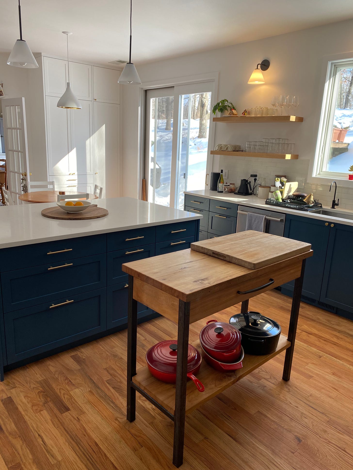 Kitchen with white counter tops and blue drawers and cupboards. 