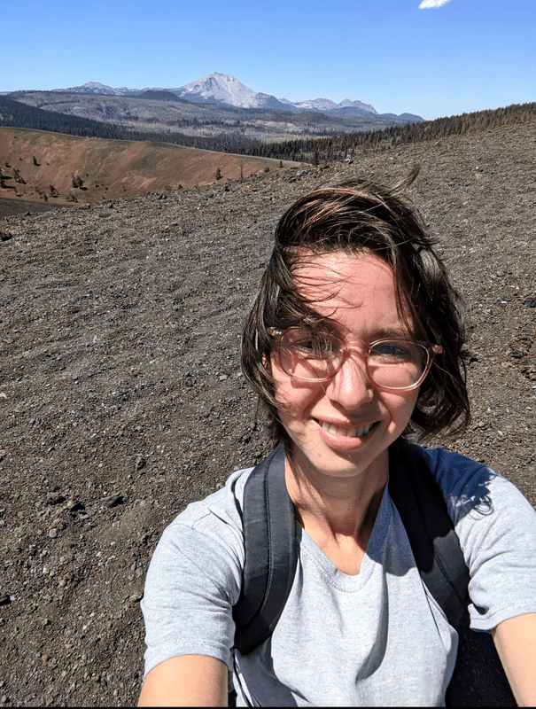 Selfie of Rey looking happy standing on top of the cinder cone volcano