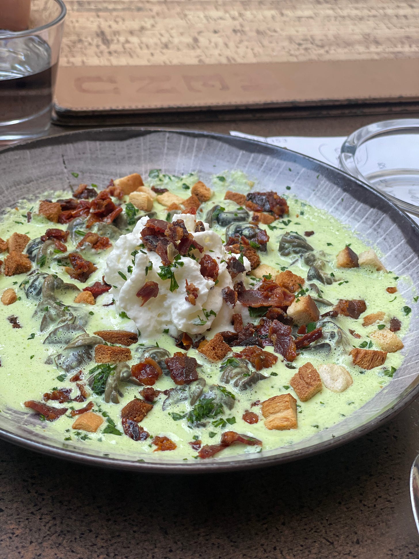 Dish containing escargots, bacon, and parsley