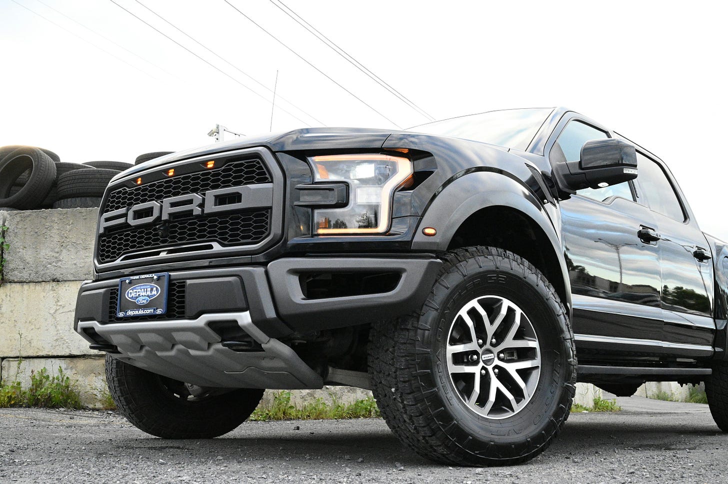 A low-angle photo of the front of a Ford F-150 pickup truck demonstrating its "aggressive" styling.