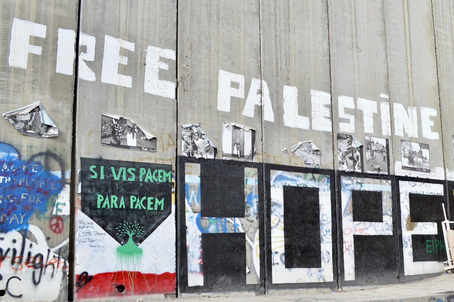 A concrete separation wall between Gaza and Israel that is full of graffiti that reads Free Palestine and Hope