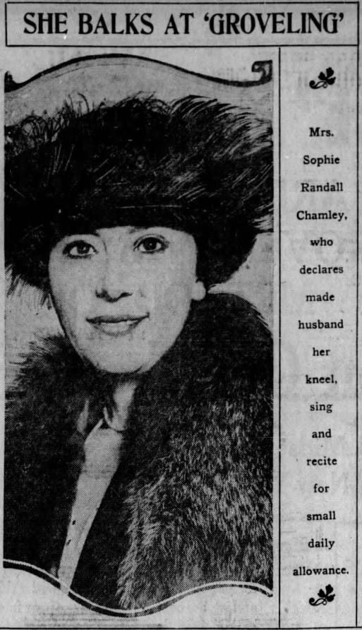A photograph of a white woman in her thirties, wearing an Edwardian feathered hat. She is looking directly at the camera and is smiling slightly. The picture has a news headline above, stating 'She balks at "groveling"'