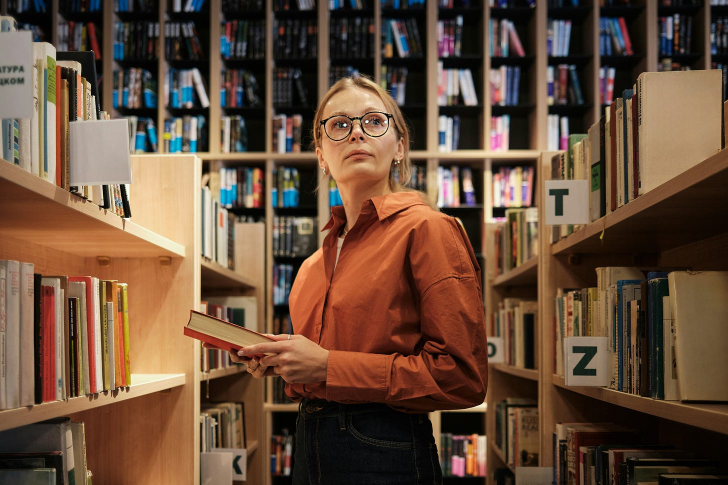 Person in a library looking confused, unhappy, and defiant