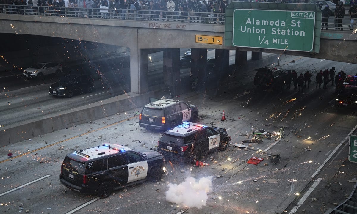 A flash bomb explodes on the 101 Freeway near the metropolitan detention center of downtown Los Angeles, on June 8, 2025, following previous night's immigration raid protest. Photo: VCG