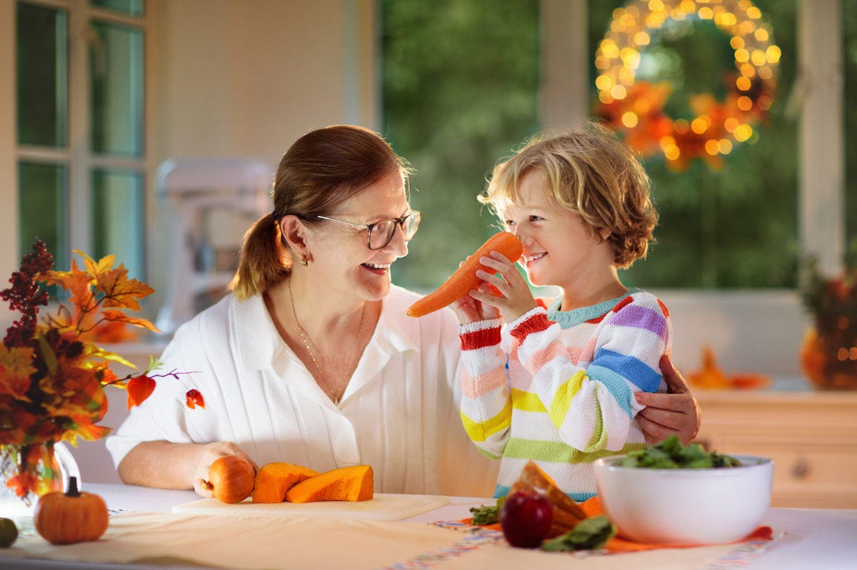 Grandmother and grandchild having fun together in the kitchen during Thanksgiving.