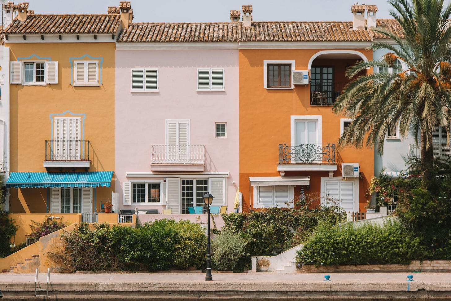 Free Vibrant Mediterranean-style houses with palm trees in Valencia, Spain. Stock Photo