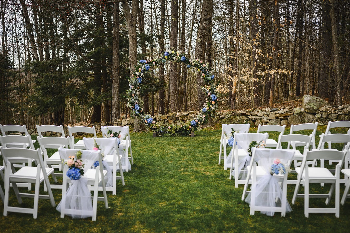 A circular, floral, wedding arbor and empty chairs before a wedding ceremony