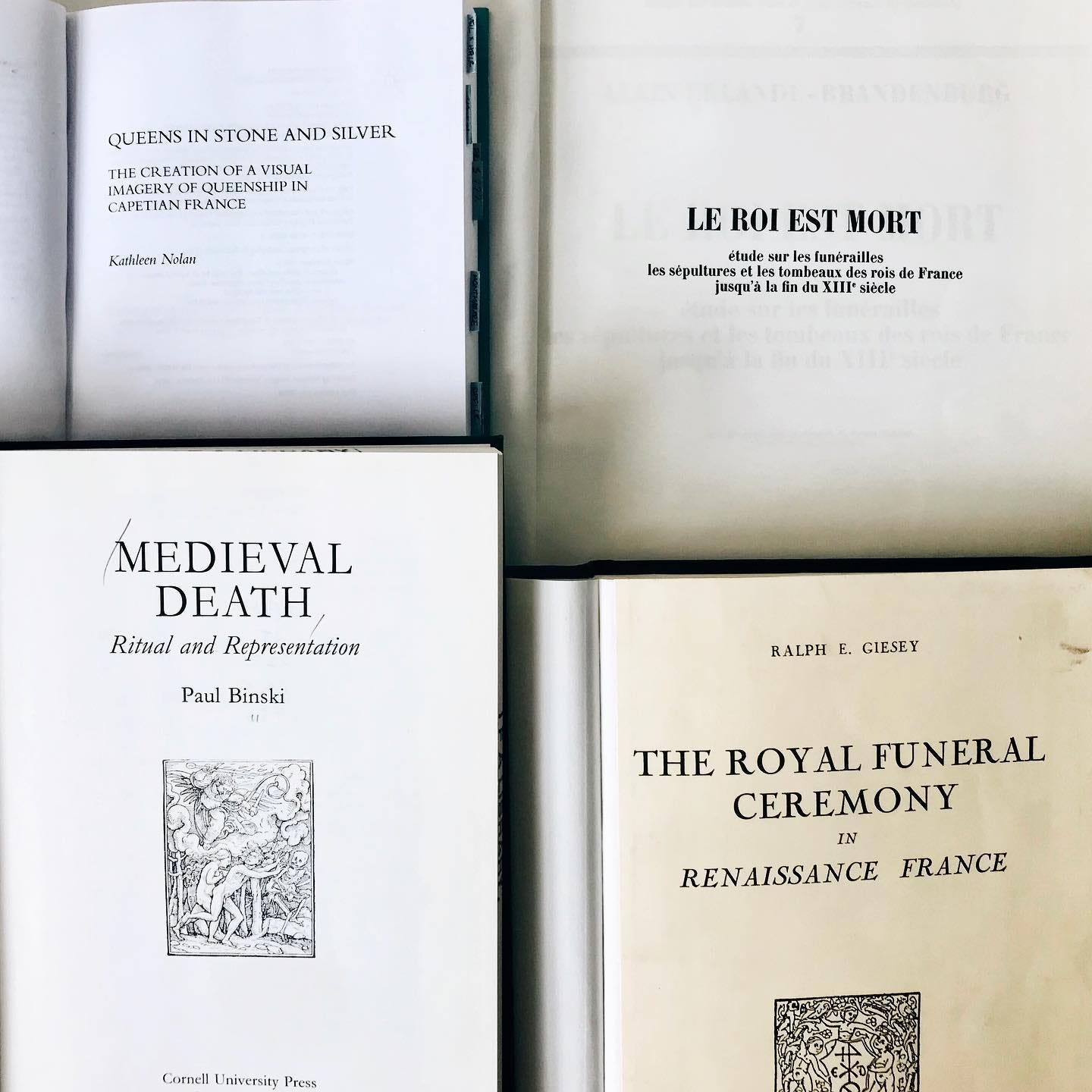 A topdown view of four books open to the title page, clockwise from top right: Le roi est mort, The royal funeral ceremony in Renaissance France, Medieval death, Queens in stone and silver.