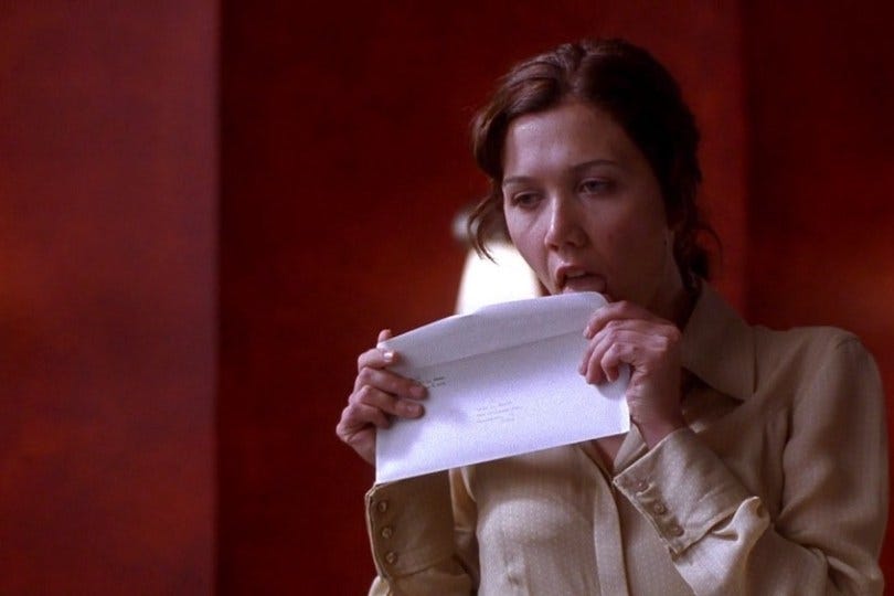 Maggie Gyllenhaal licks an envelope in "Secretary" (2002)