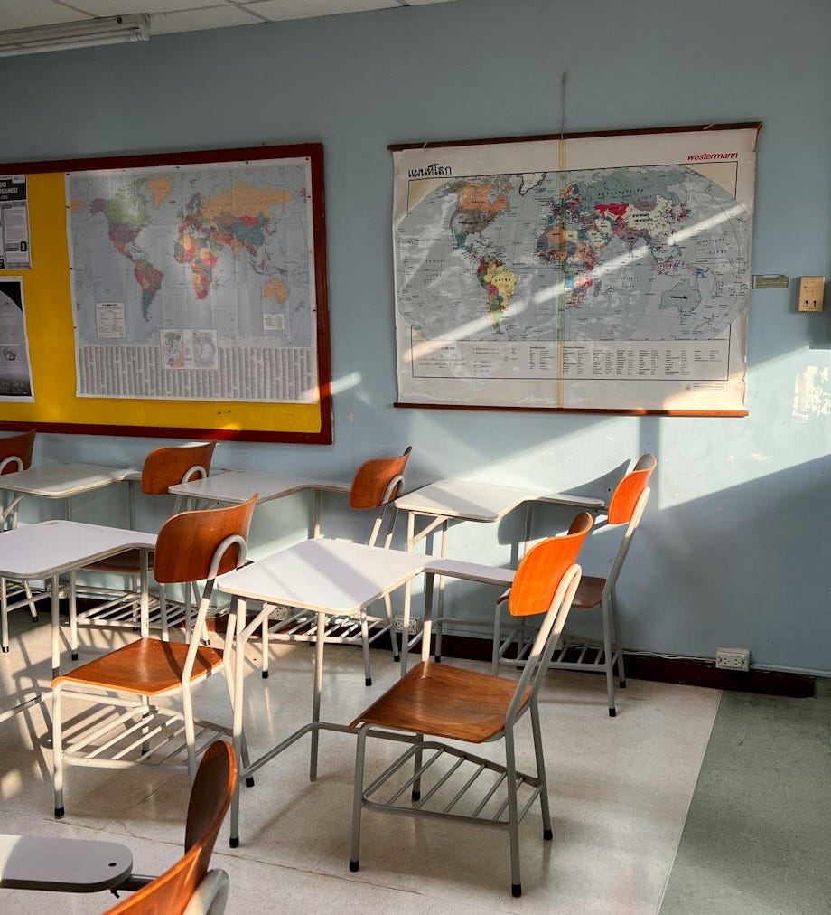 a classroom with a map hanging on the wall