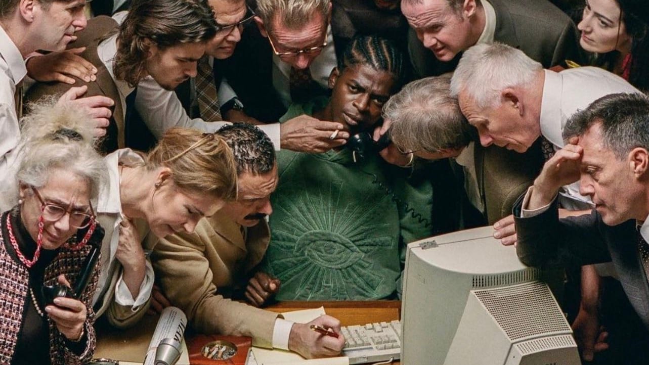 A man sitting at a desk. Many people surround him and do his tasks: holding his phone, holding his cigarette, etc. A man sitting at a desk. Many people surround him and do his tasks: holding his phone, holding his cigarette, etc.