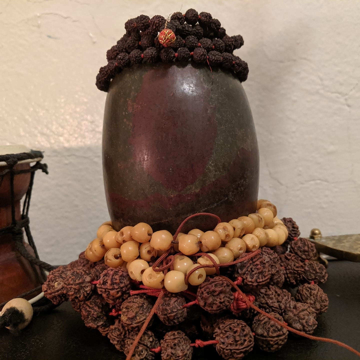 image: stone Siva lingam decorated with rudraksha and bone beads