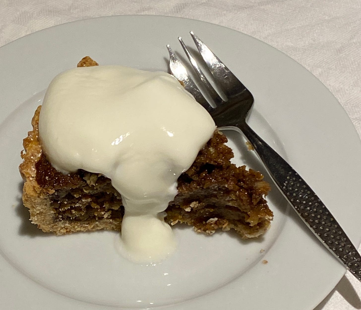 Treacle and Apple Tart on a plate, served with plain yoghurt.