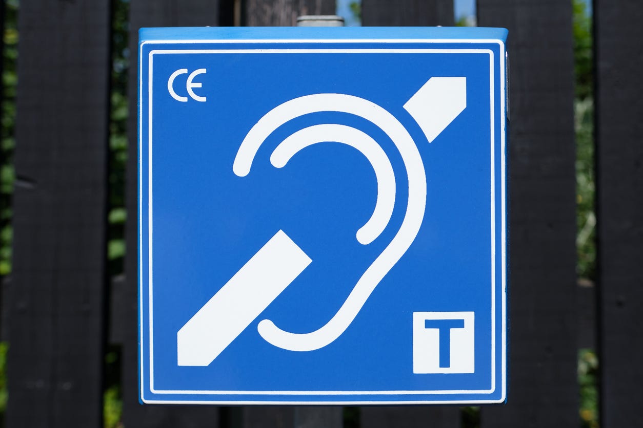 Hearing loop sign with a crossed out ear and a T symbol on a blue background Hearing loop sign with a crossed out ear and a T symbol on a blue background