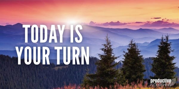 Sunset over expansive land and mountains with backlit fir trees in the foreground. Text overlay: Today Is Your Turn