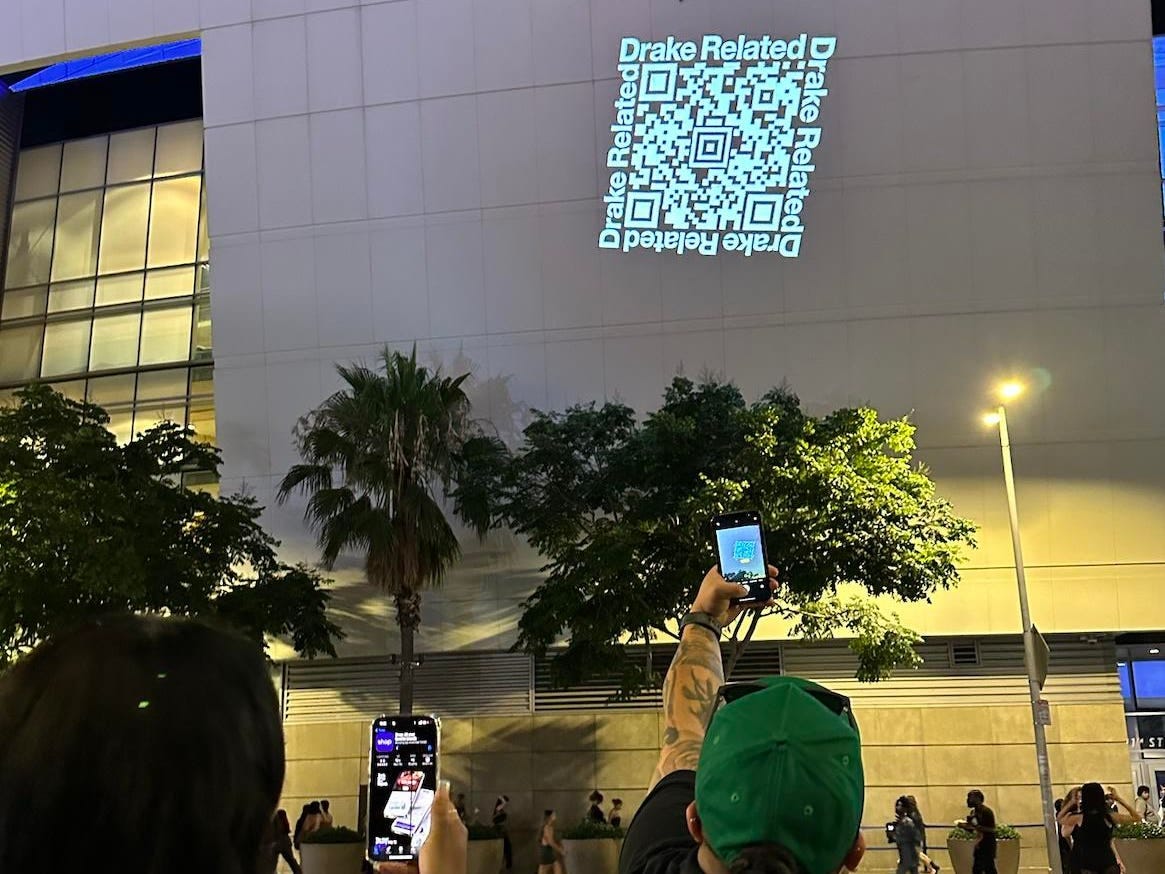 Fans downloading the Drake Related QR code at a Drake concert to access newly released merchandise.