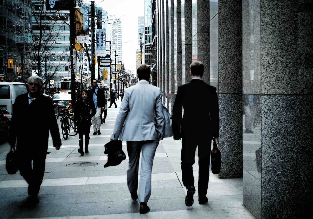 Two business men walking down a busy city street