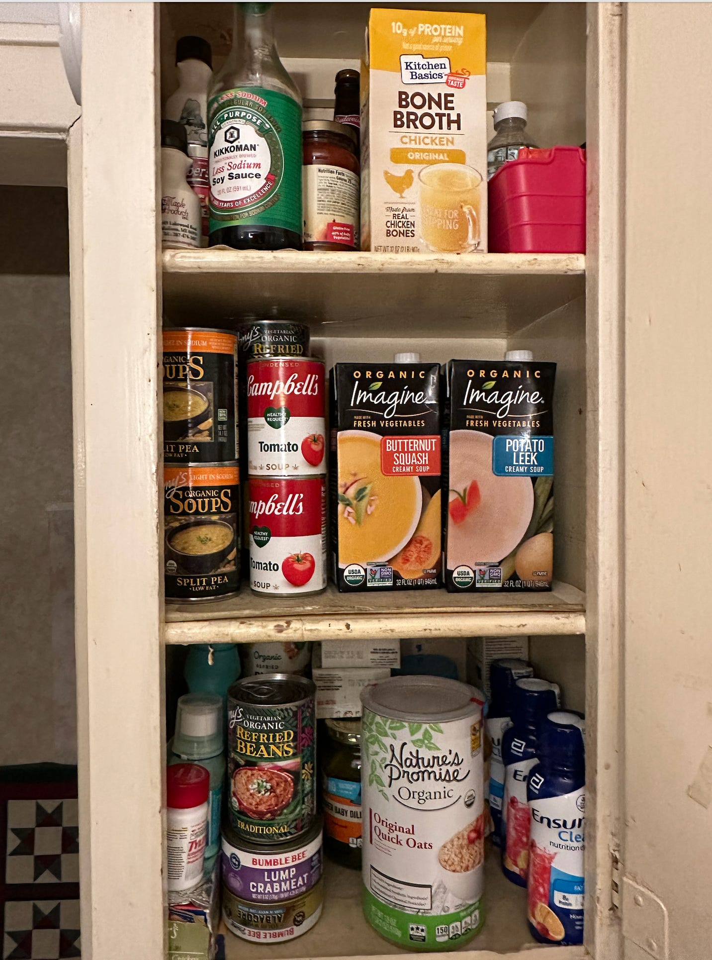A pantry cabinet full of different kinds of soup