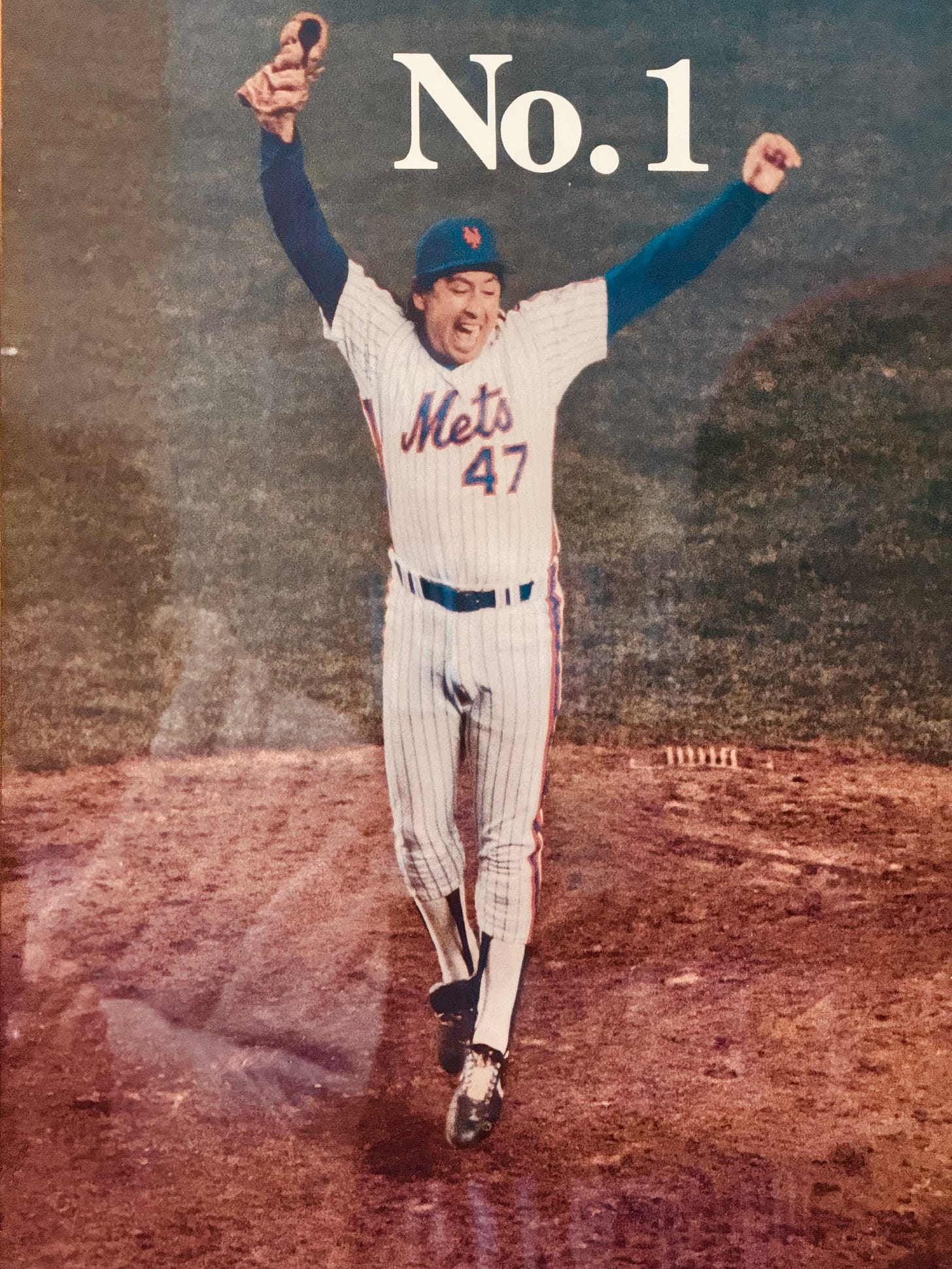 Jesse Orozco Mets Pitcher wearing Mets uniform raising his hands in victory, The words No. 1 are printed at the top.