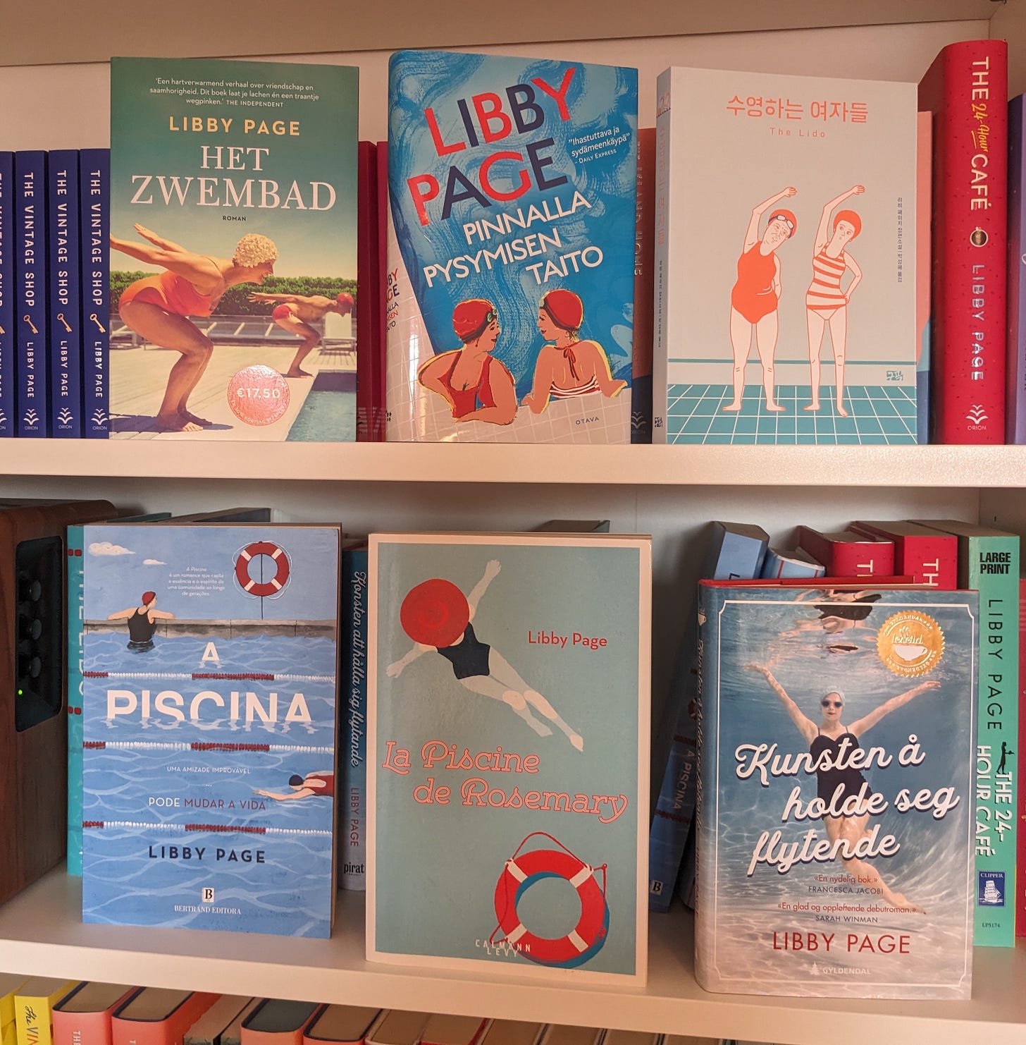 Six foreign editions of The Lido by Libby Page on a shelf, with a variety of different style covers. Some are photographic and others are illustrative.