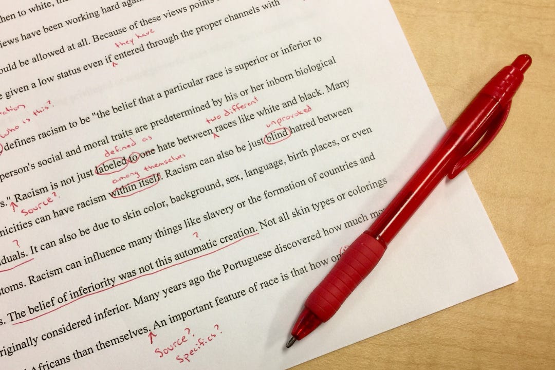 an essay with a red pen and lots of corrections