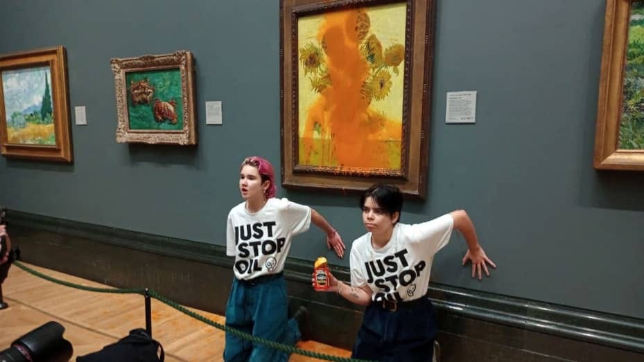 Activists of "Just Stop Oil" glue their hands to the wall after throwing soup at a van Gogh's painting "Sunflowers" at the National Gallery in London, Britain October 14, 2022. Just Stop Oil/Handout via REUTERS    THIS IMAGE HAS BEEN SUPPLIED BY A THIRD PARTY. MANDATORY CREDIT