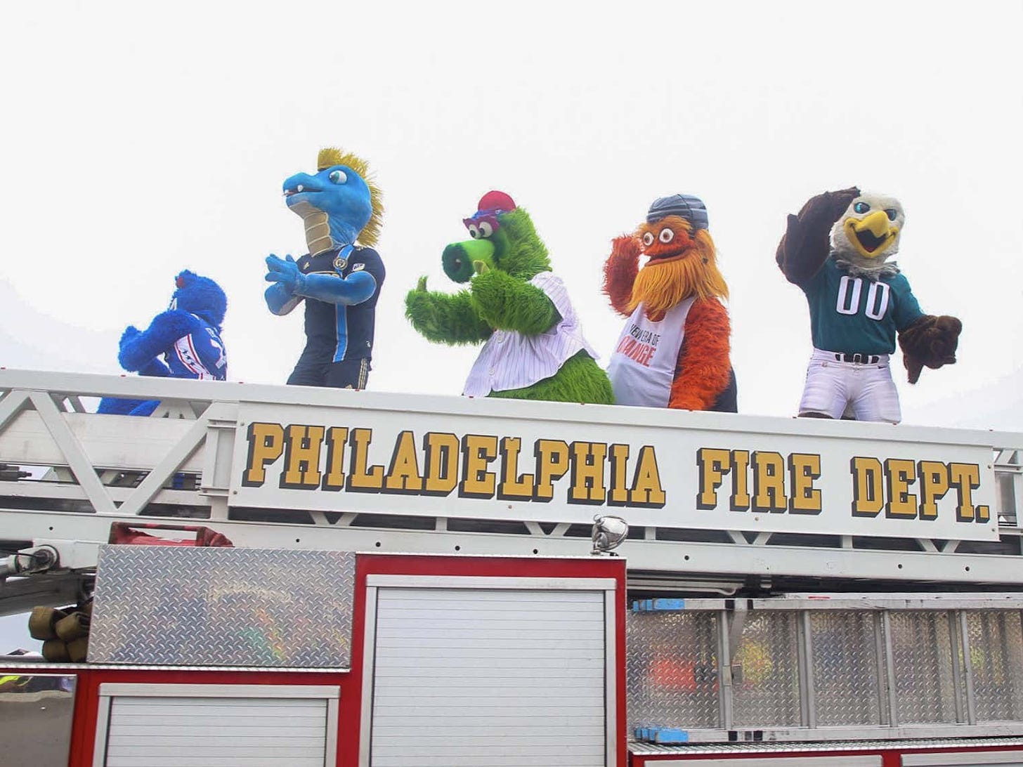 Philadelphia sports mascots riding a fire engine across I-95