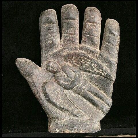 This may contain: an old stone hand that has been carved to look like it is holding something in its palm