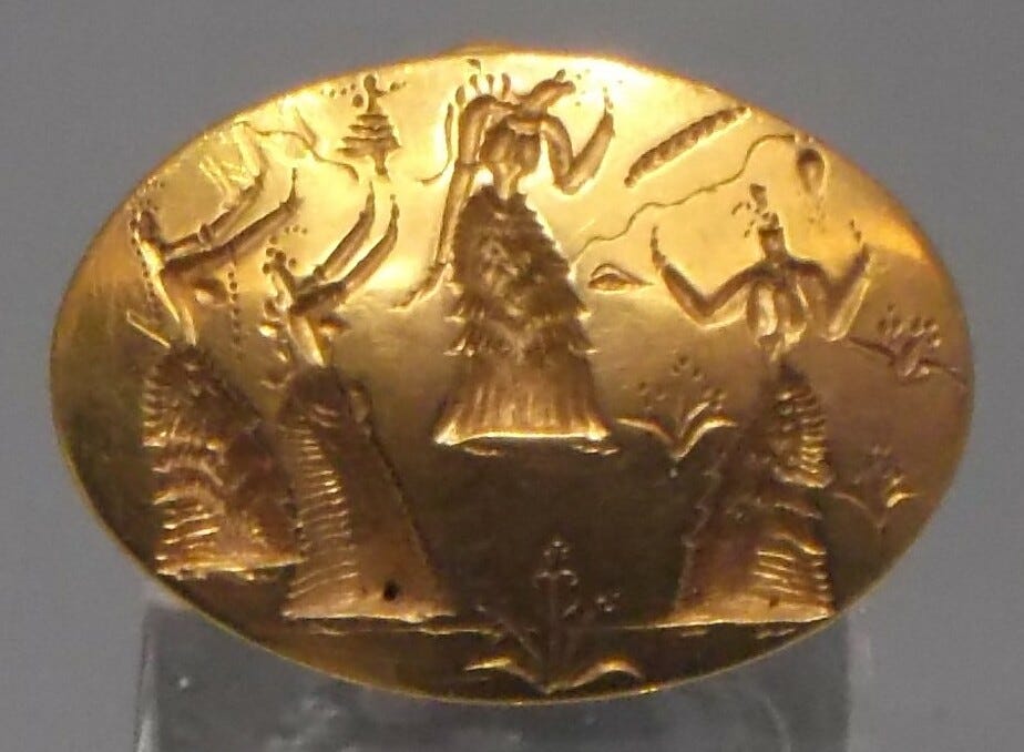 The top of an oval ring with the molded-in image of four priestesses performing a ritual surrounded by lilies, other shapes, and a small goddess figure descending from above.