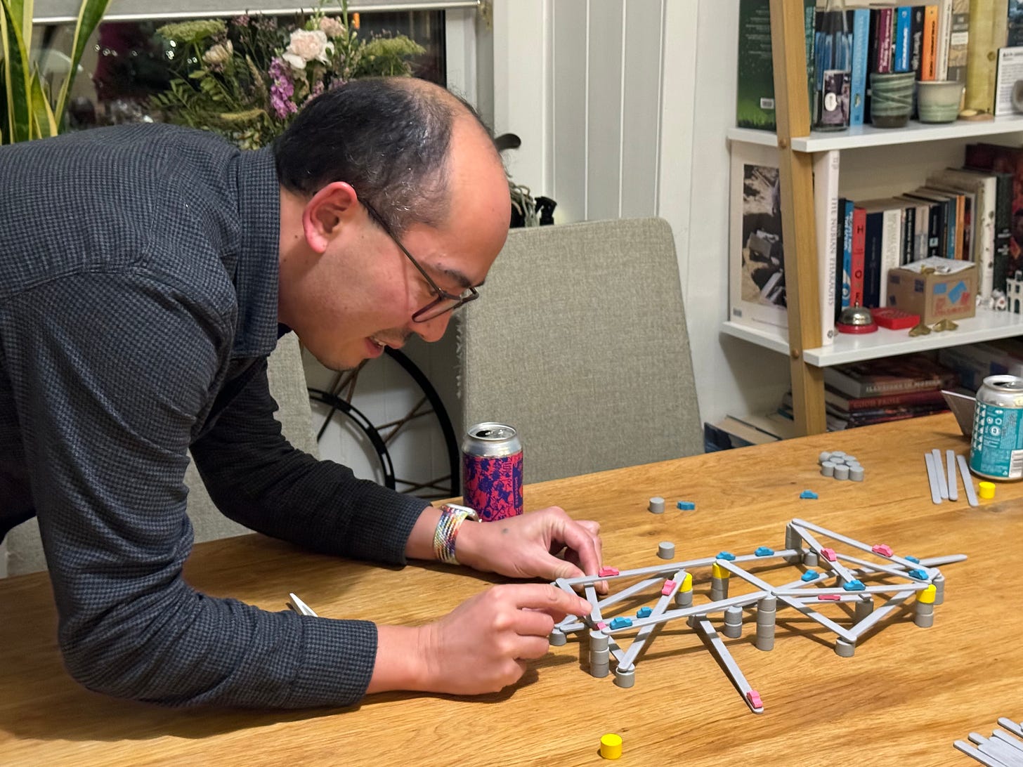 Adrian adjusting the position of a miniature highway on a board game