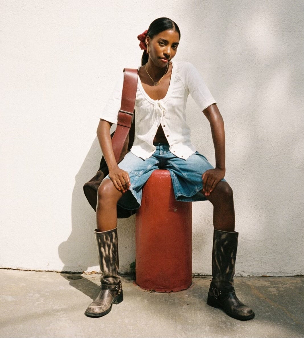 Photo of Tyra Booker sitting on a stool-like structure