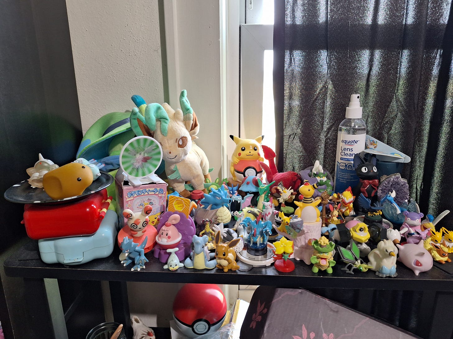 Another shelf of figures, plush toys and collectables, featuring a cute Leafeon plush, a Spinda figure, and an adorable Lapras!