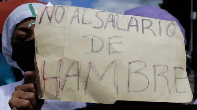 Una enfermera muestra un cartel que dice "No al salario de hambre". Una enfermera muestra un cartel que dice "No al salario de hambre".