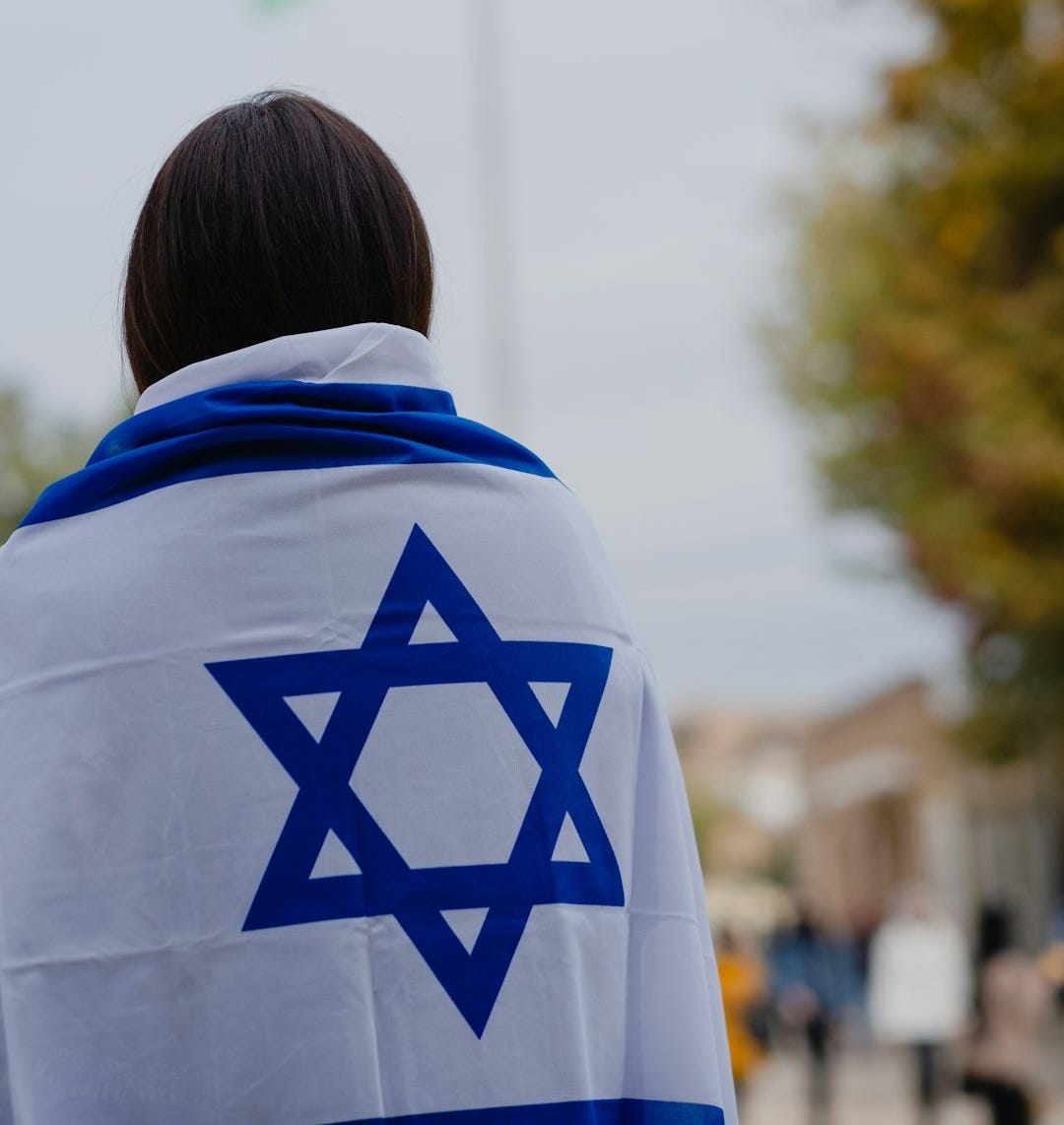 woman in white and blue hoodie standing near green trees during daytime woman in white and blue hoodie standing near green trees during daytime