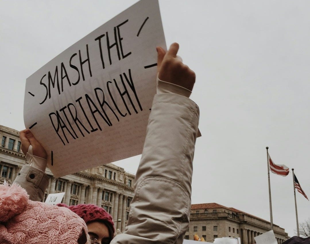 woman holding white paper with smash the pairtarchy