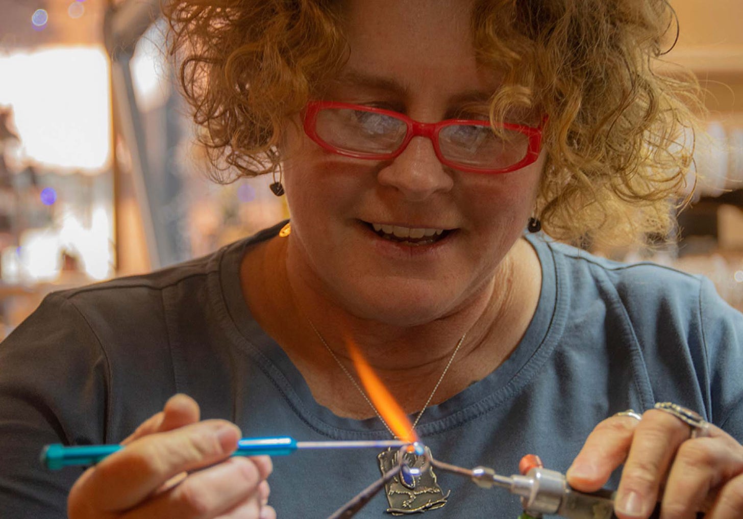 Woman fusing metal together with a jewelers torch