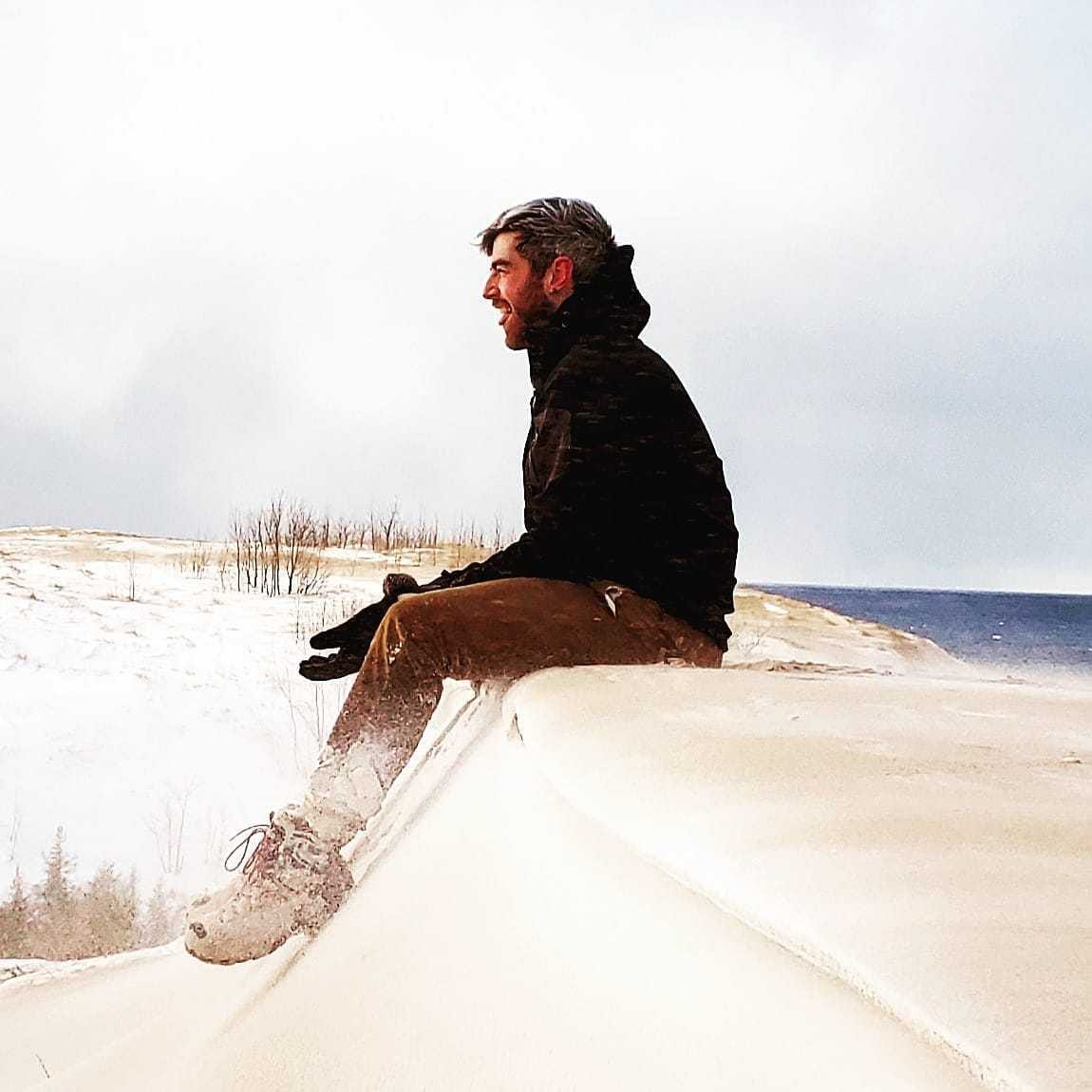 A man sits on a dune