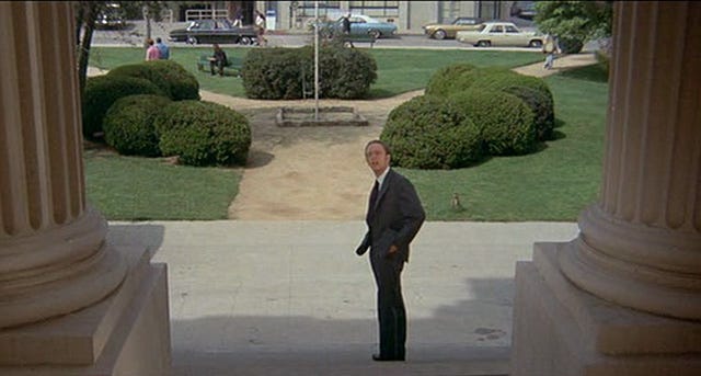 Widok w kierunku placu przed budynkiem, zza kolumn - kadr z komedii "How to Frame a Figg" (1971)
