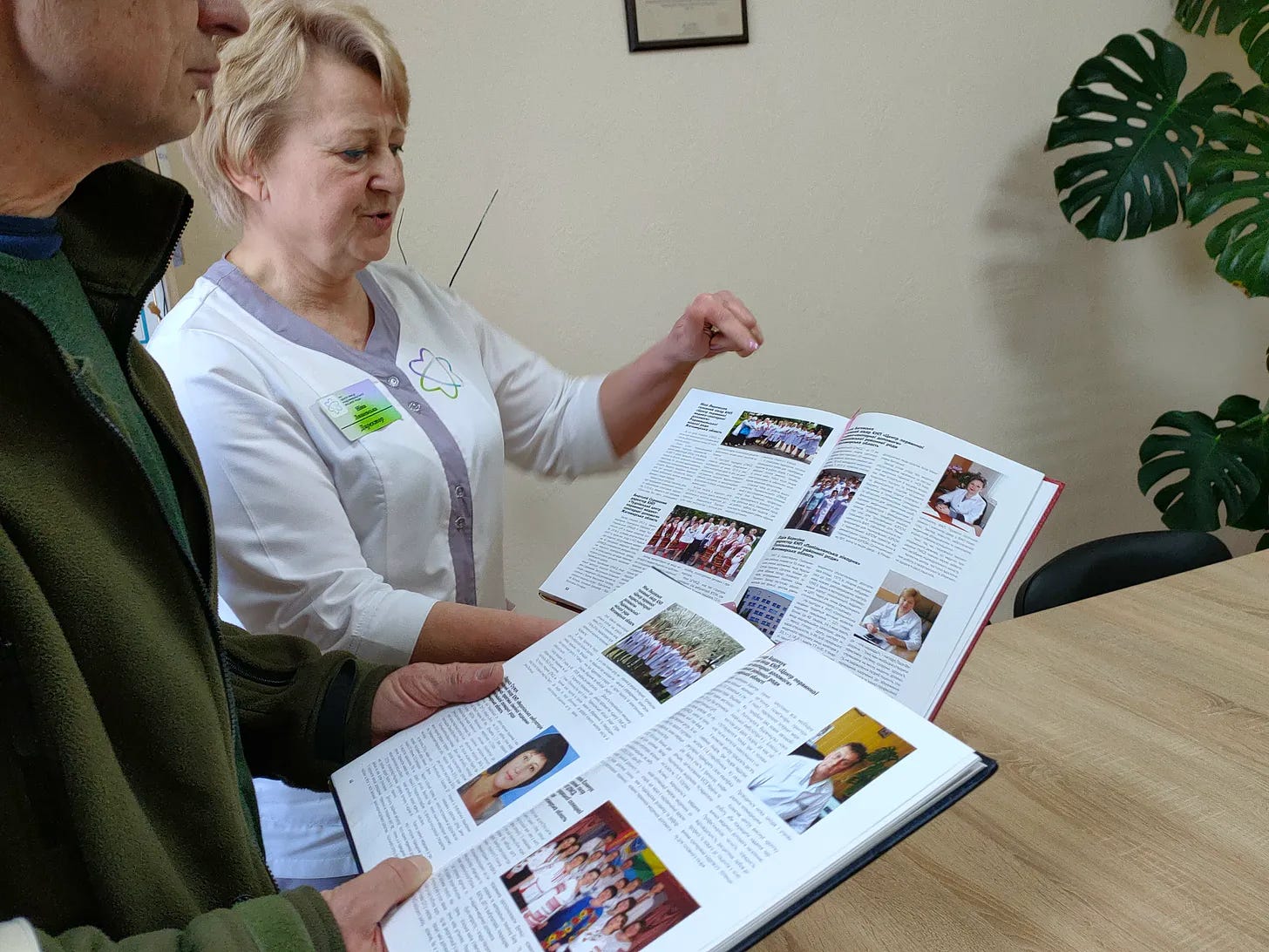 Nina Lyashevska zeigt auf einen Artikel über ihre Einrichtung zur primären Gesundheitsversorgung in Radomyschl. Dank der Fördergelder aus einem Projektgewinn sind alle Räume hell und freundlich ausgestattet.