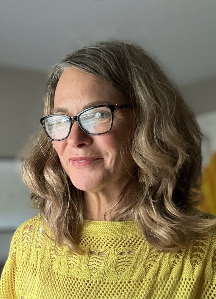 A person wearing glasses and a yellow sweater

Description automatically generated