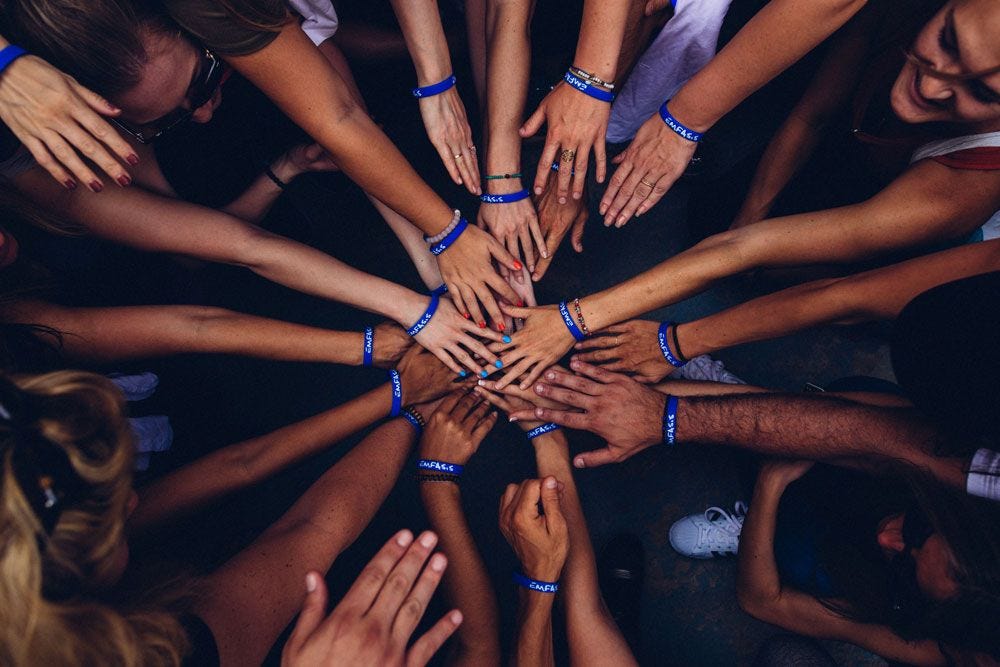 Hands reaching into the center of frame to make a cricle