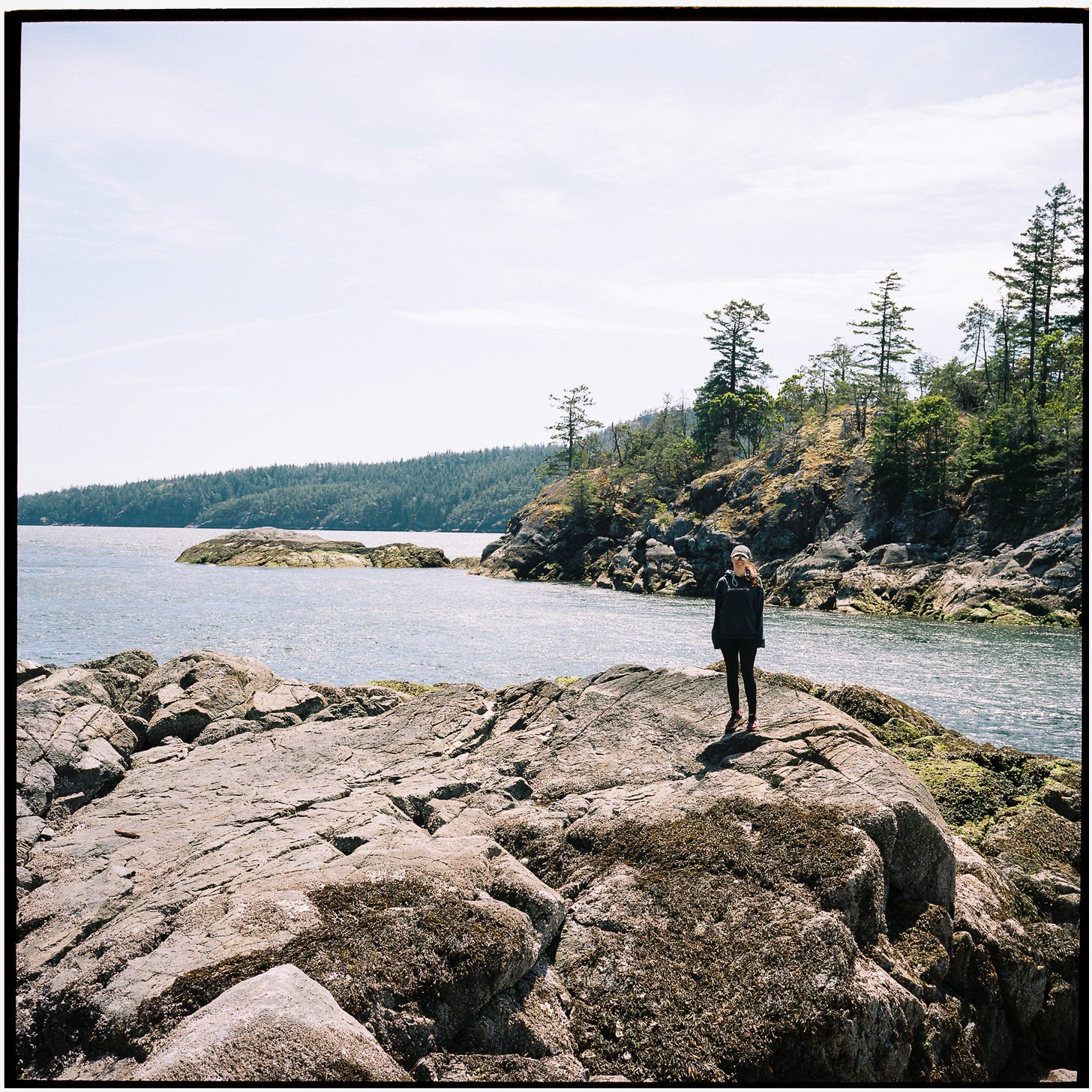 Photo of Maddie on a rocky outcropping by the ocean