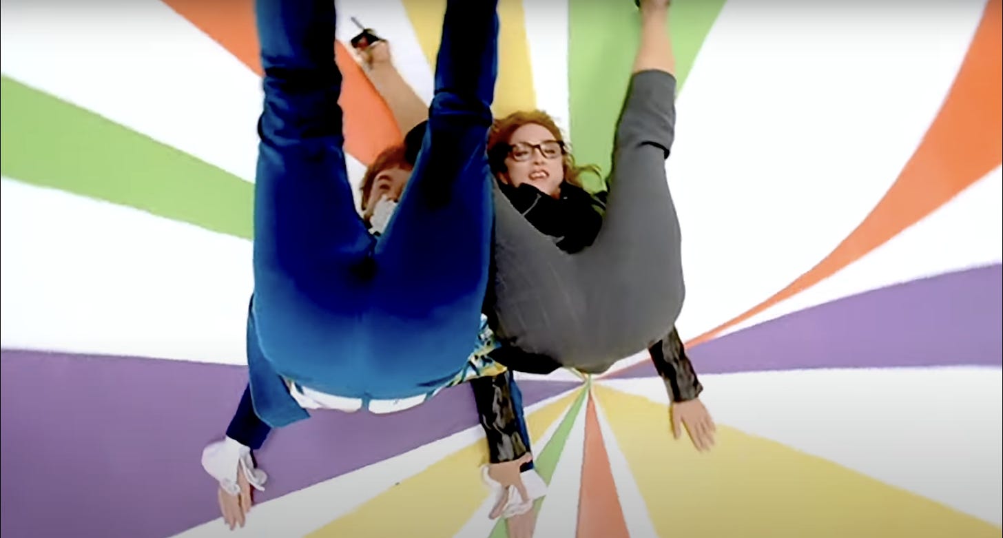 Madonna and Austin Powers lie on a kaleidoscope floor with their rears in the air in the Beautiful Stranger vide