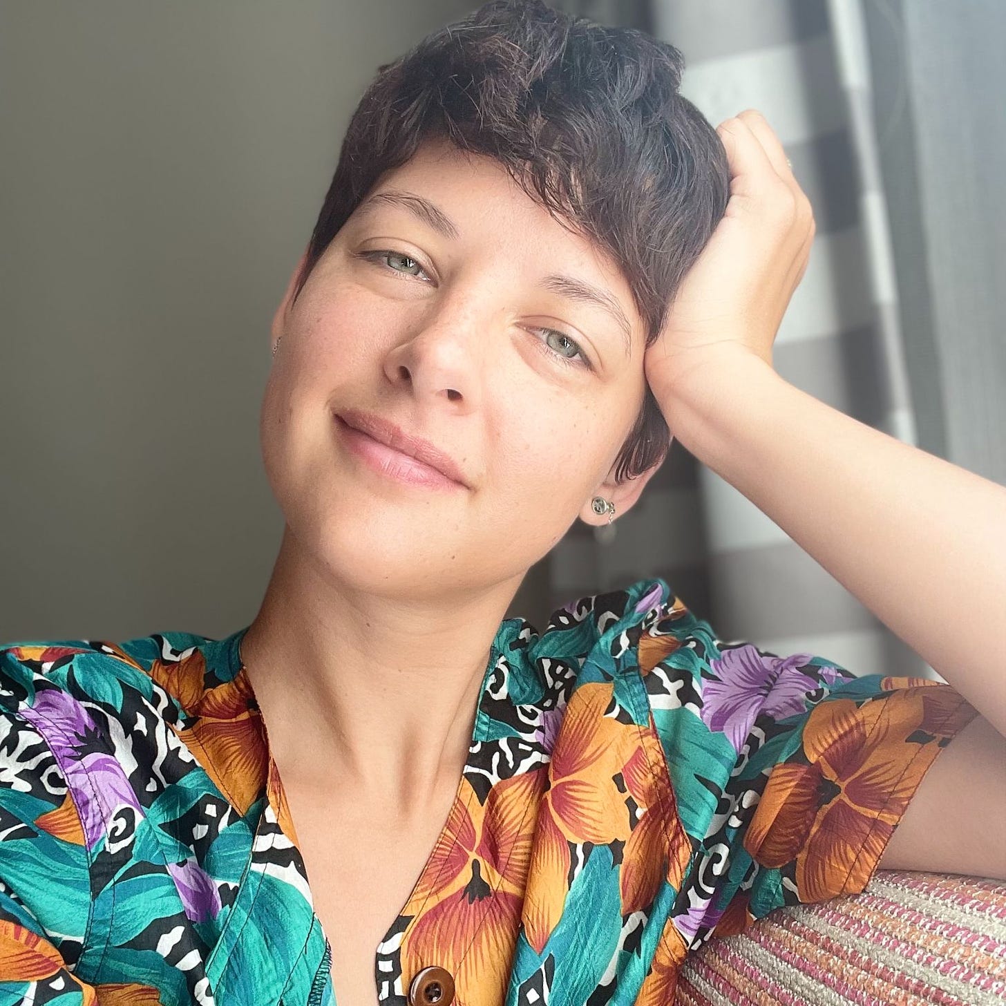 a non-binary professional in a floral shirt