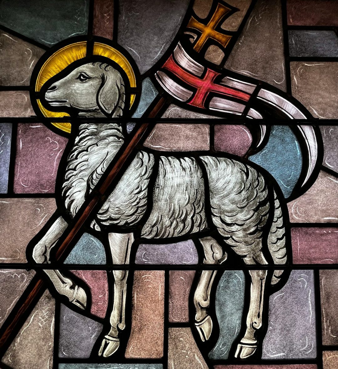 a stained glass window with a sheep holding a flag