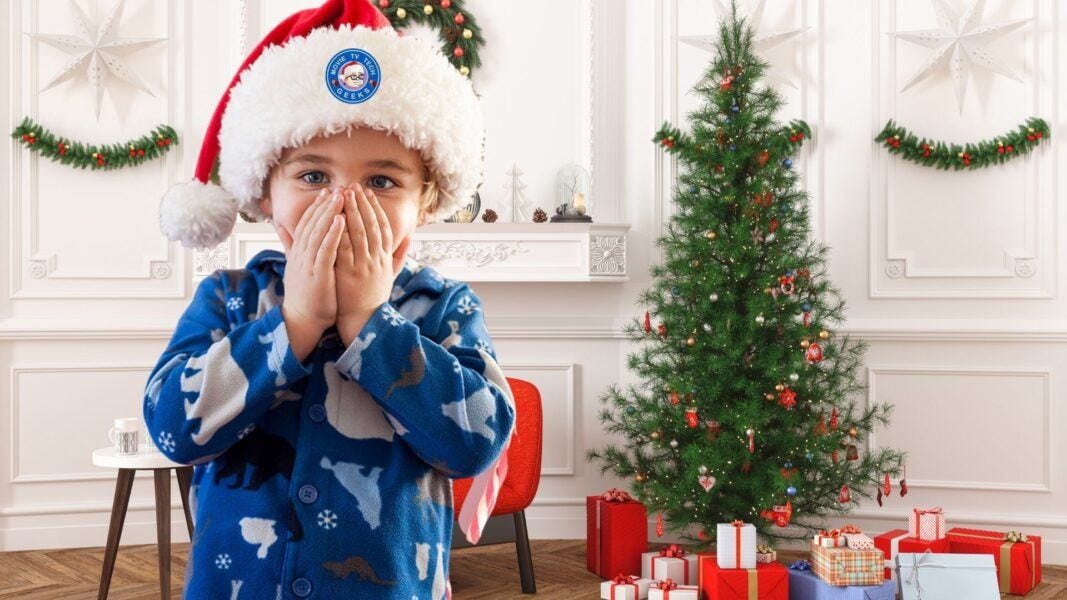 young boy in santa hat excited with christmas gift guide 2021