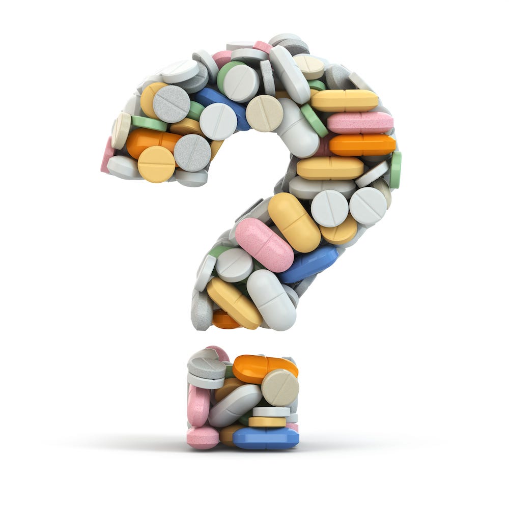 Photo-style image of a question mark made out of pills of many different colors, sizes, and shapes. Symbolizes questions about medication.