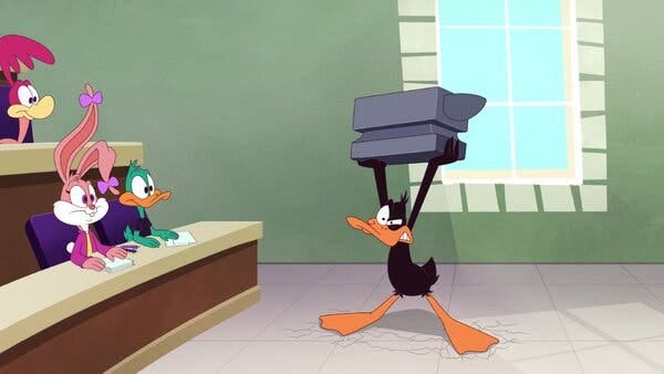A cartoon duck struggles to hold an anvil above his head in a lecture hall setting as three students — a duck, a road runner and a rabbit — look on.