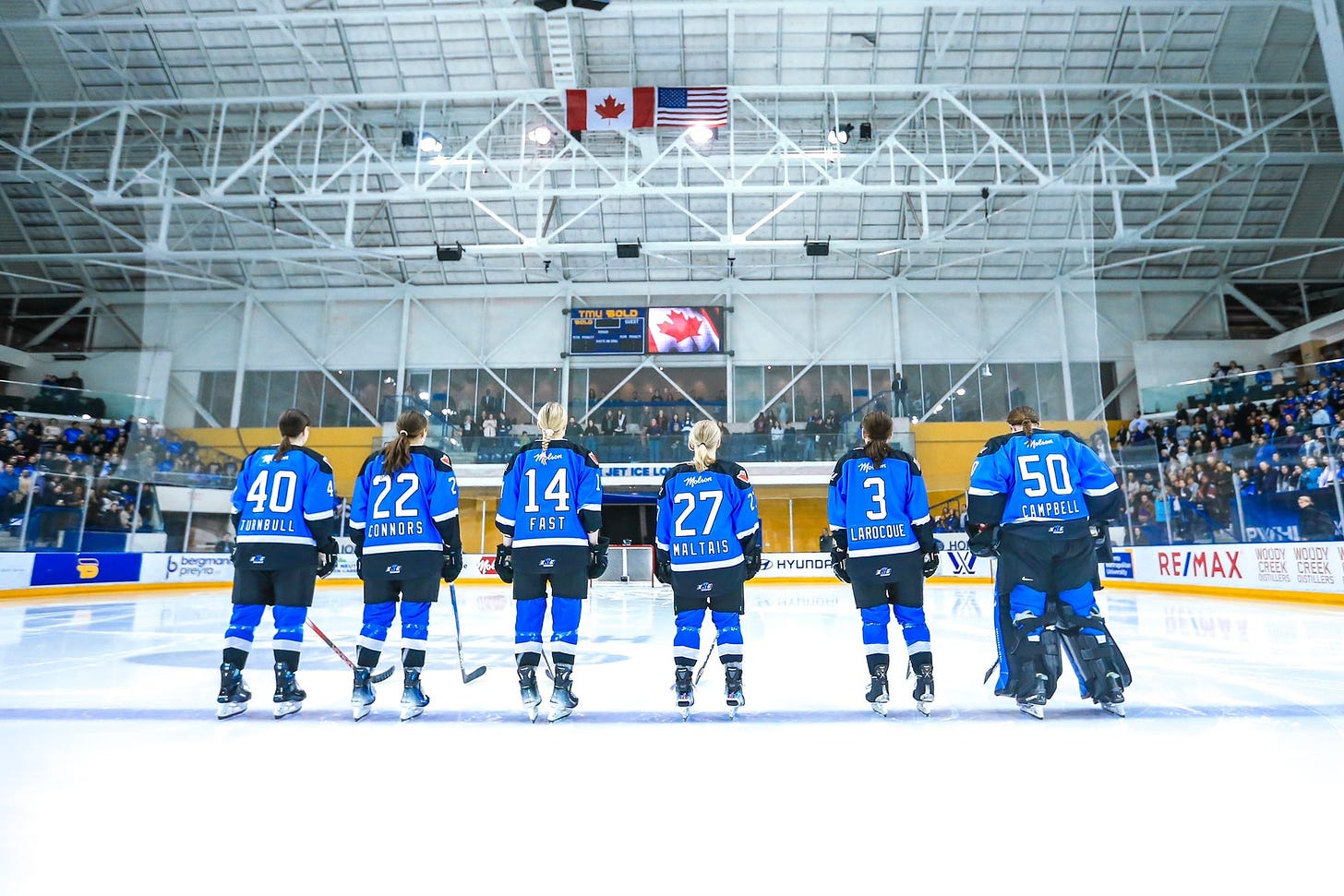 Five PWHL Toronto players, Turnbull, Connors, Fast, Maltais, Larocque, and Campbell, standing at center ice for the national anthem.