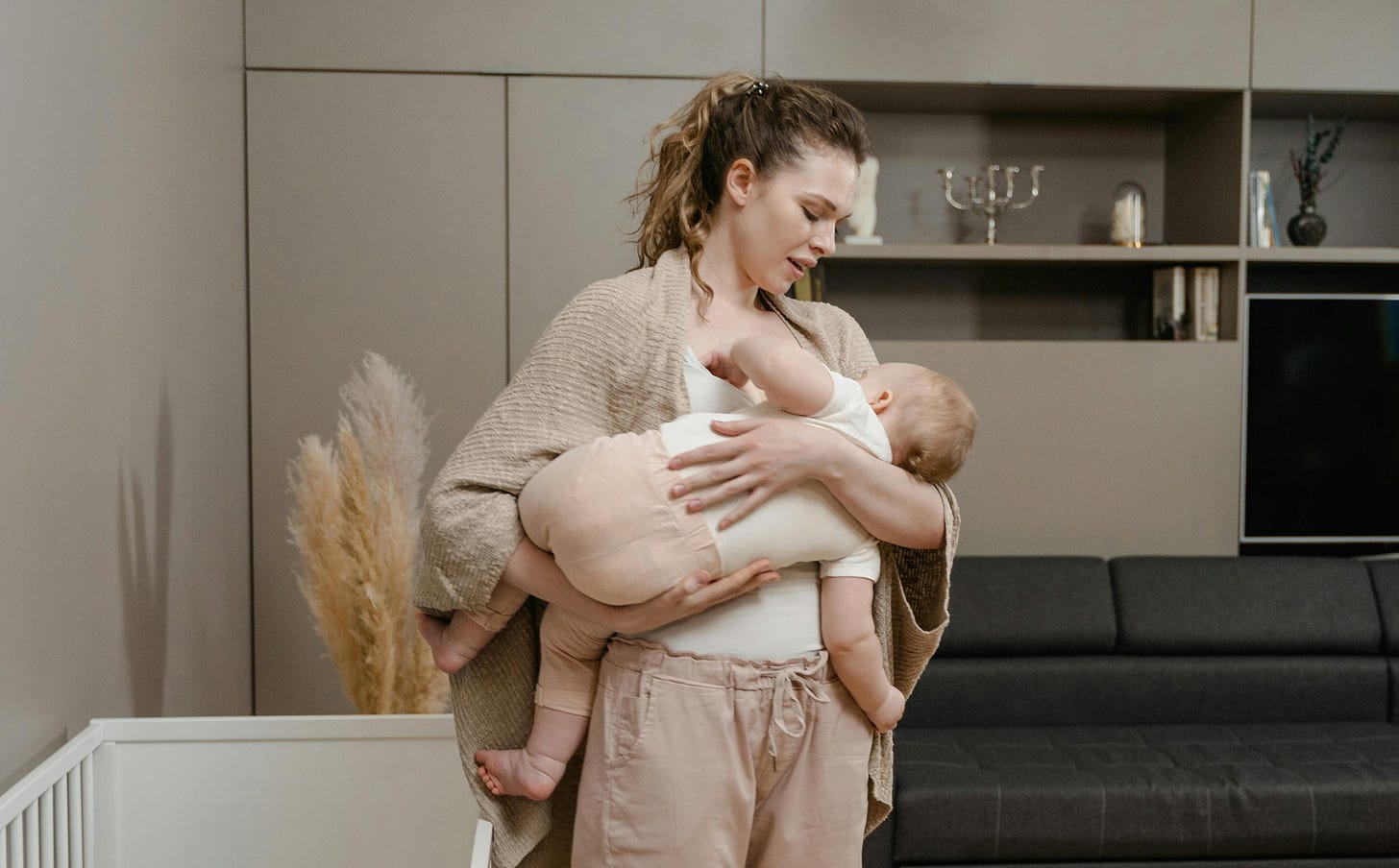 Una mamma culla e canta una ninna nanna al proprio bambino o bambina